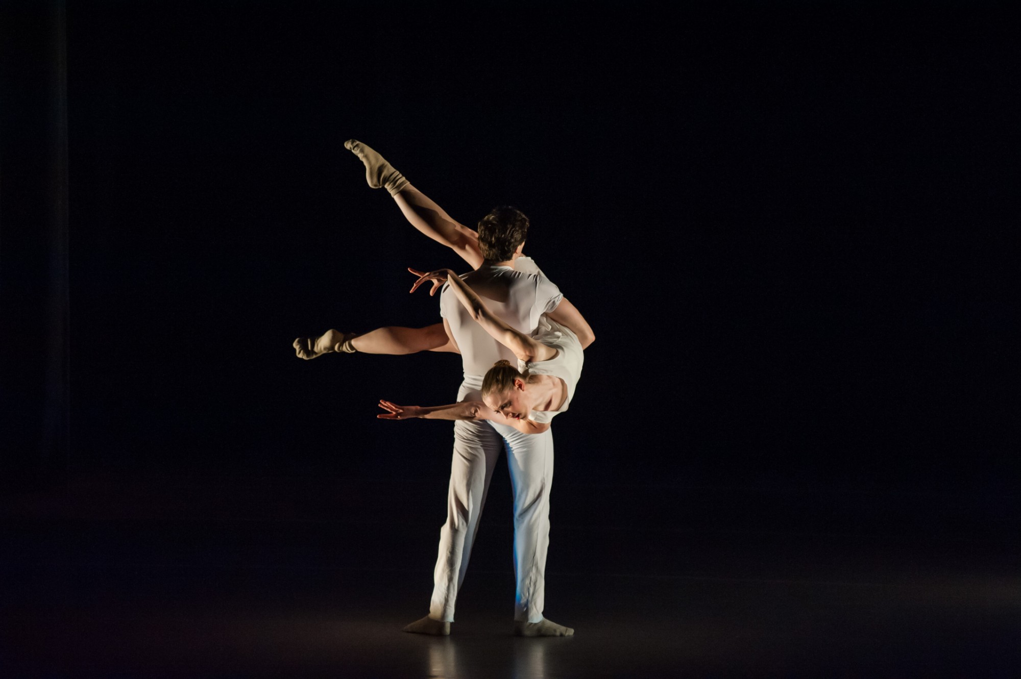 Two dancers in white performing a lift